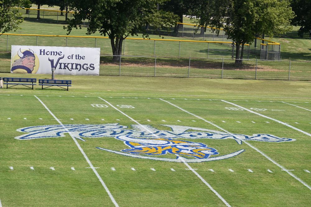 In the center of the football field the word Parsons is wrrotten in bubble cursive letters with a large Viking head under it