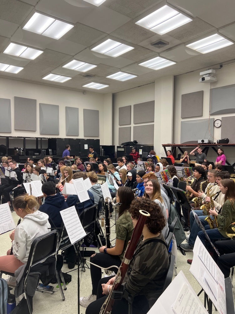 Group of band students in room preparing for rehearsal