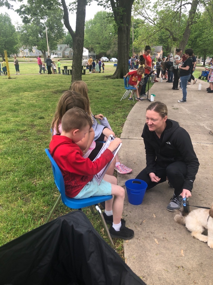 students reading to a parent at the park