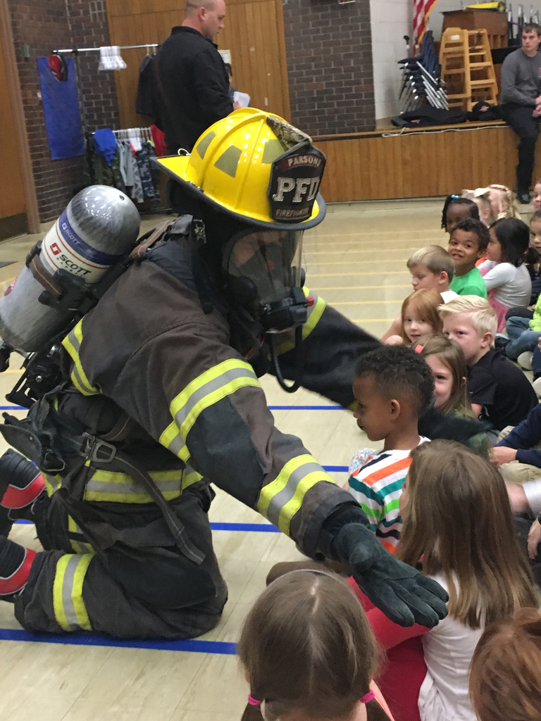 Firefighter giving high five to students