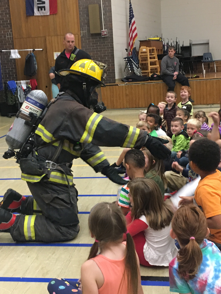 Firefighter giving high five to students