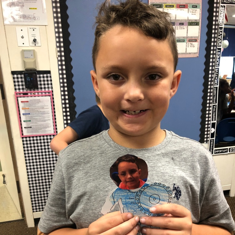 student holding a paper Viking they colored