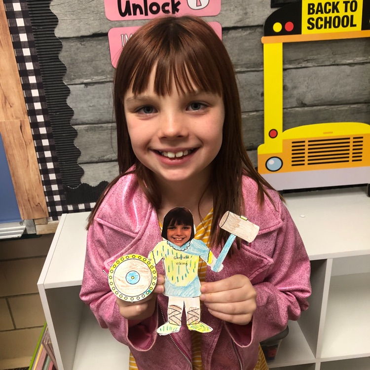 Student holding a paper Viking that has their picture as the face.